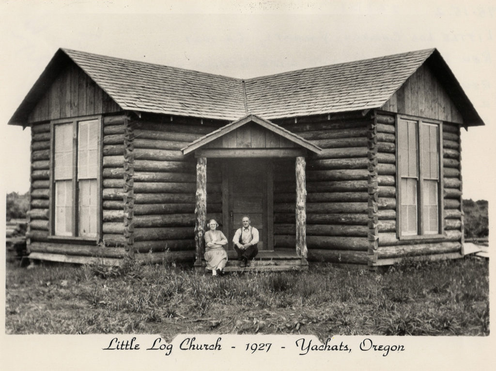 black and white (vintage) photo: Little Log Church - 1927 - Yachats, Oregon (woman and man seated on porch of cabin)